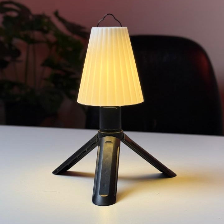 Small table lamp with a white shade on a reflective surface